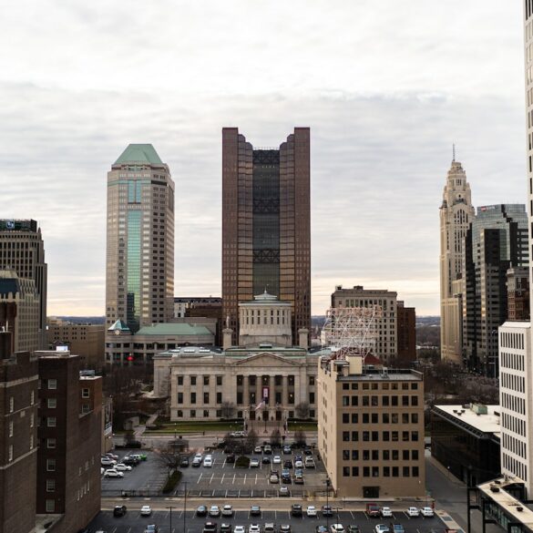 Image of the Ohio statehouse from a distance, surrounded by skyscrapers