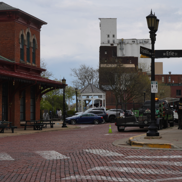 Photo of a red brick road intersection in downtown Kent. The street signs on the corner read franklin ave and Erie Street