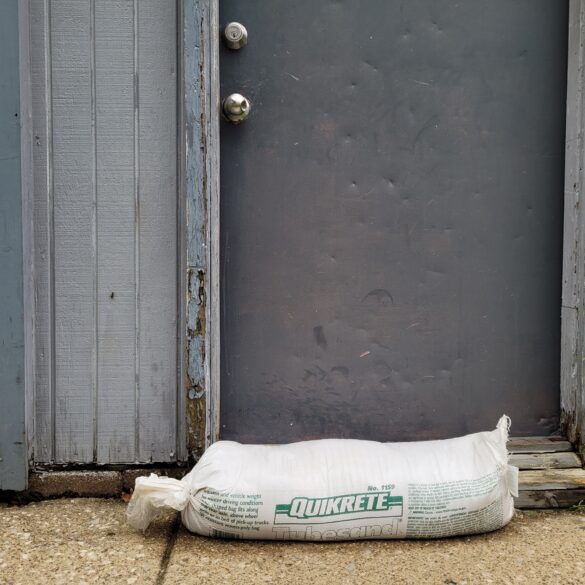 An image of a small sandbag in from of an apartment door