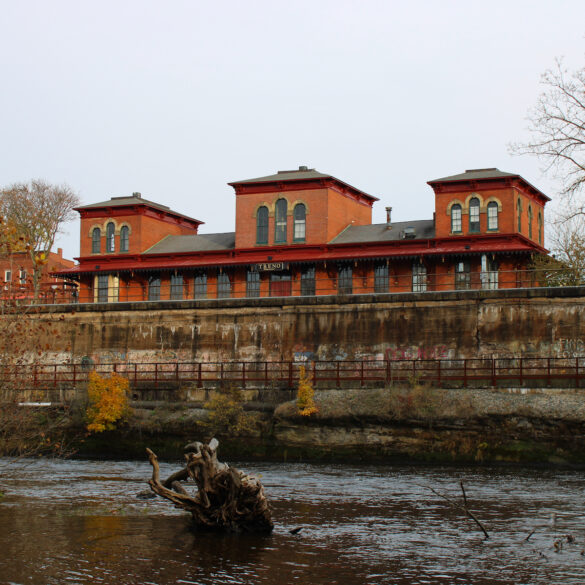 Image of an early 20th century red brick train station seen from across the Cuyahoga River