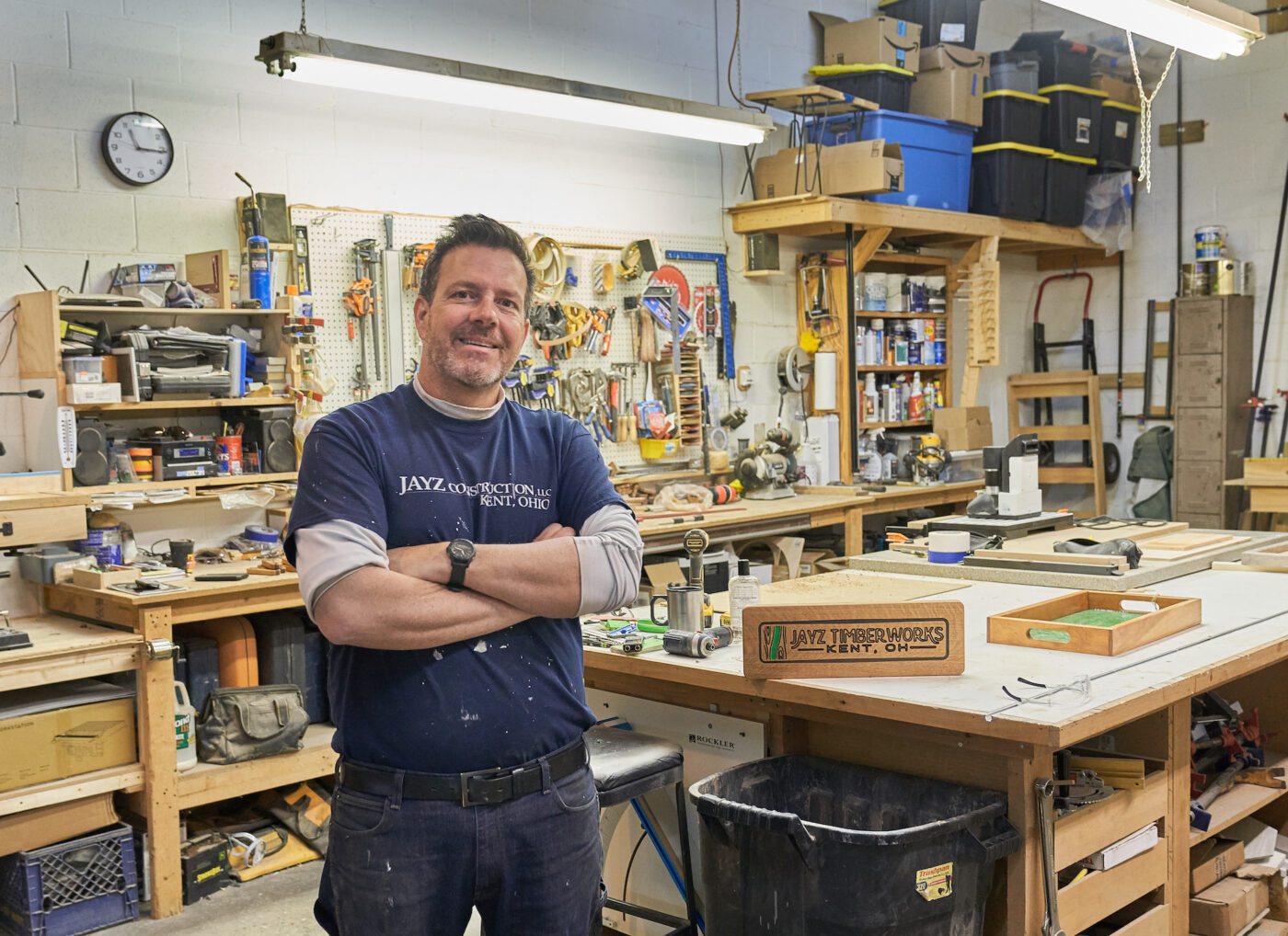 Image of a smiling, middle-aged white man standing in his woodworking shop